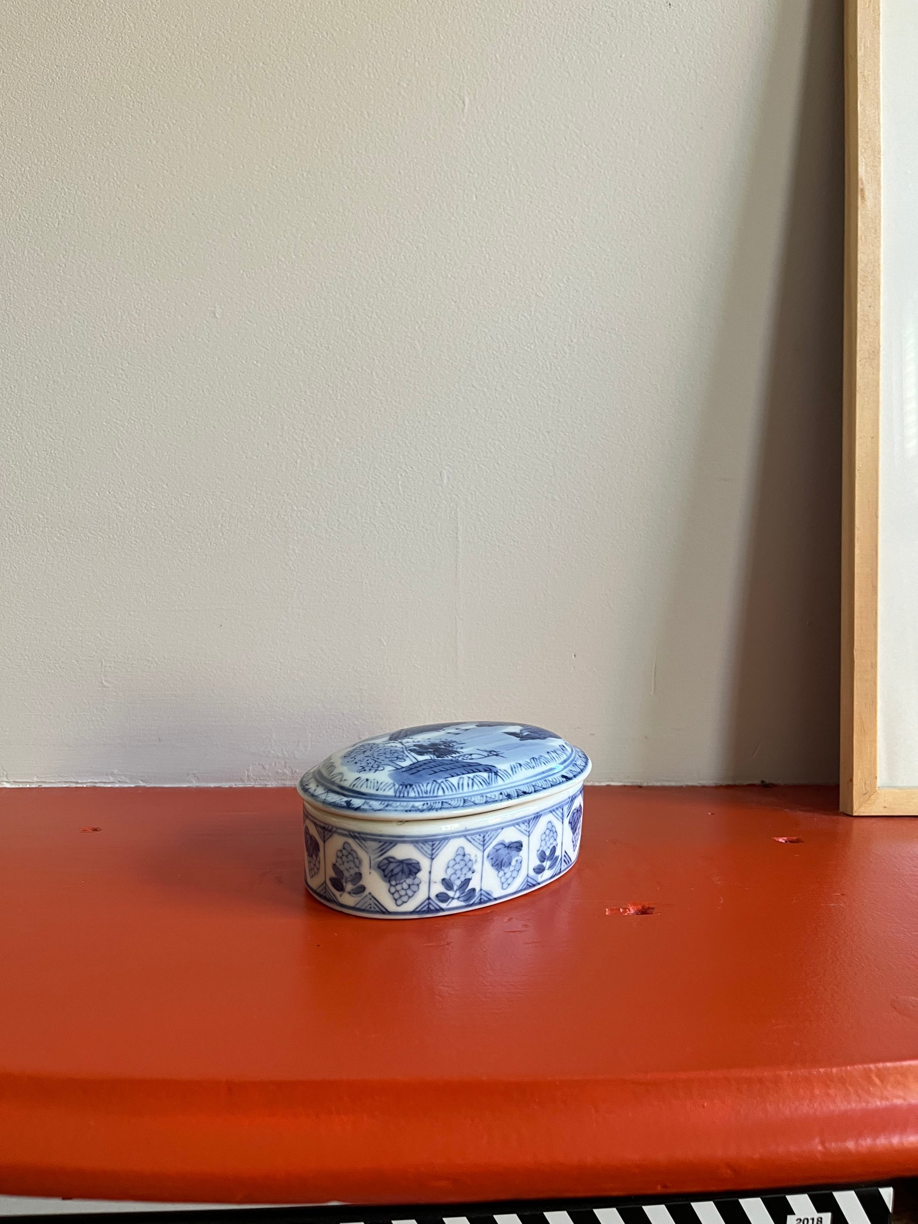 Vintage porseleinen doosje met blauw en wit decor.