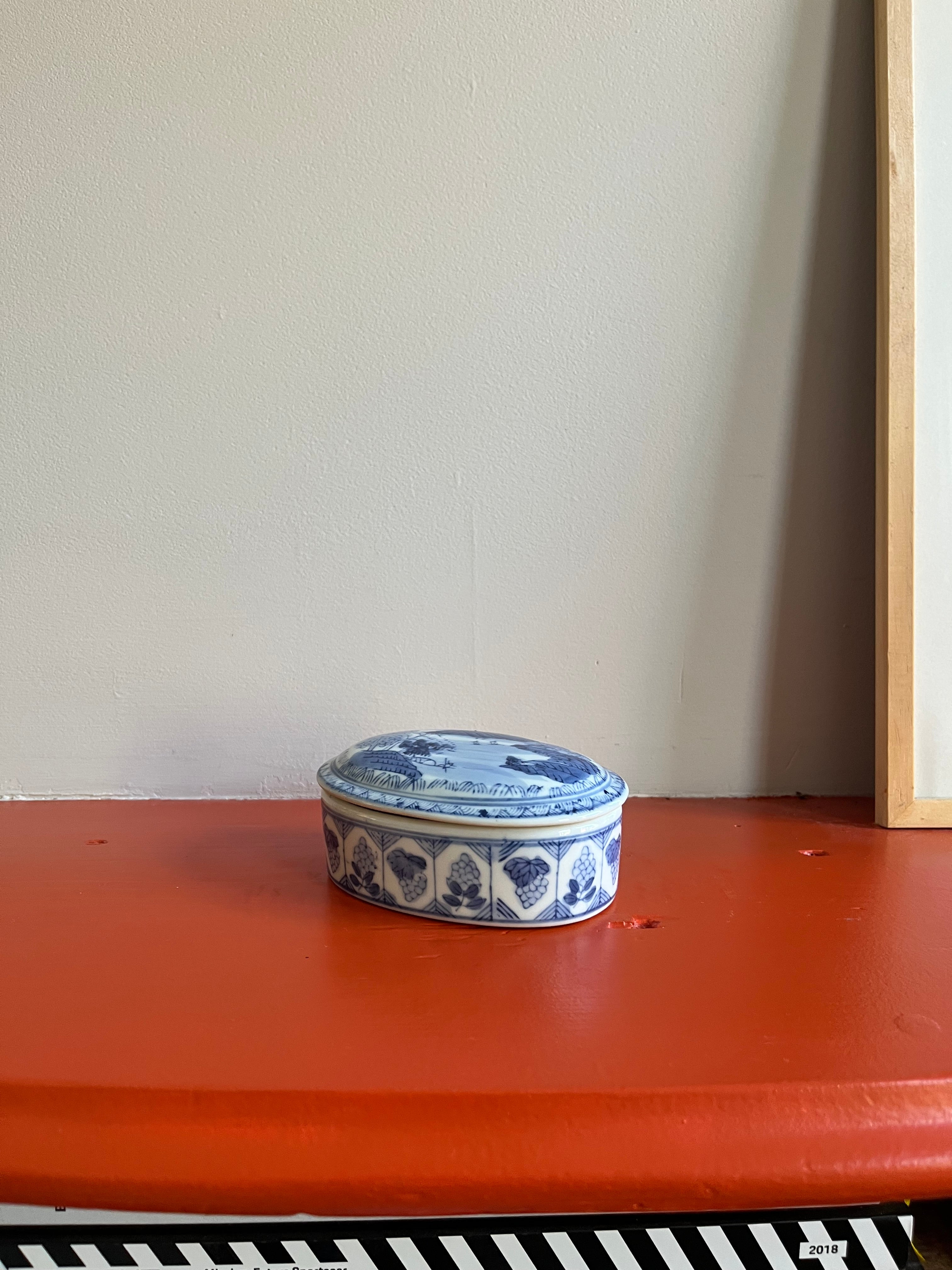 Vintage porseleinen doosje met blauw en wit decor.