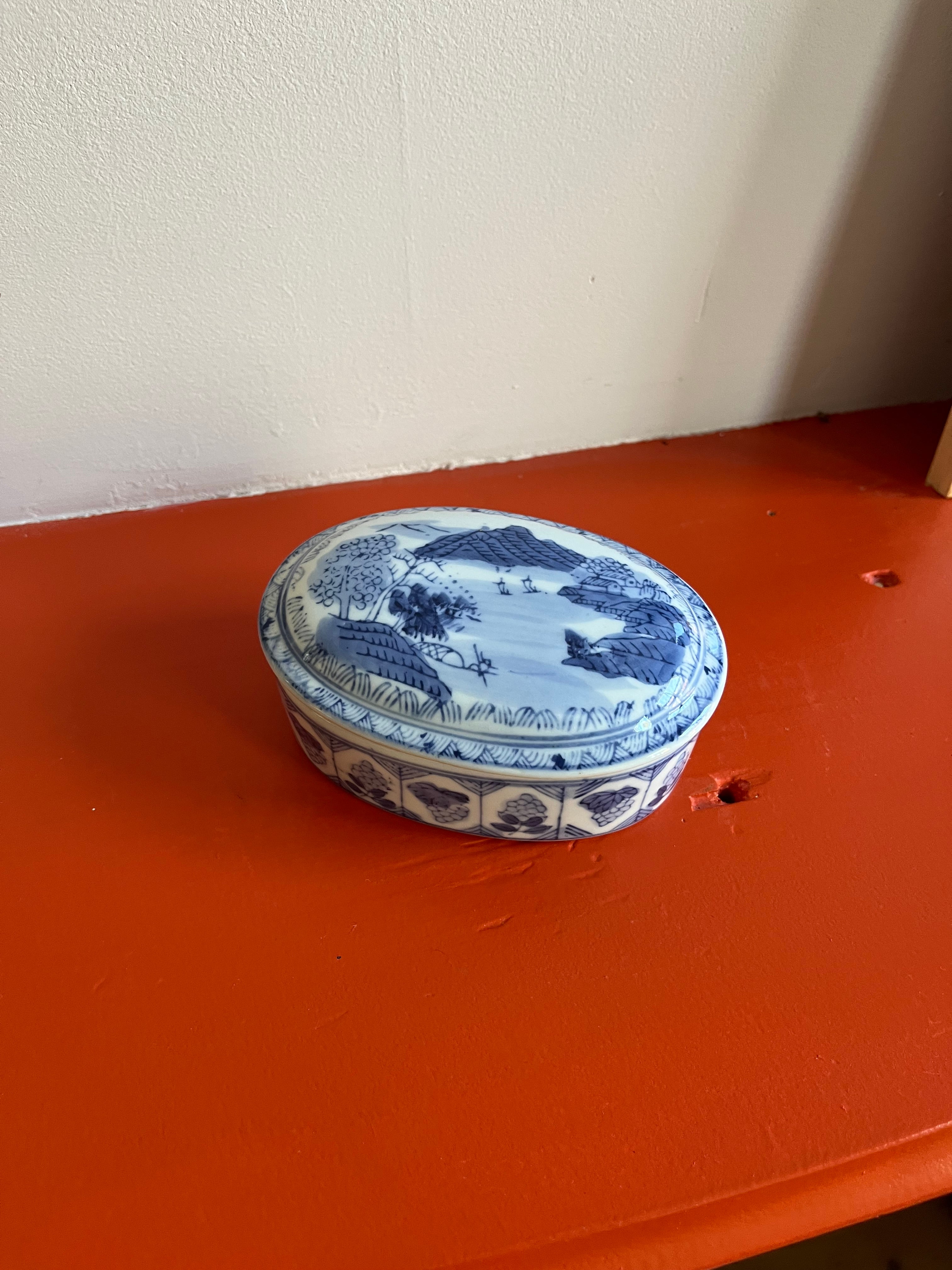 Vintage porseleinen doosje met blauw en wit decor.