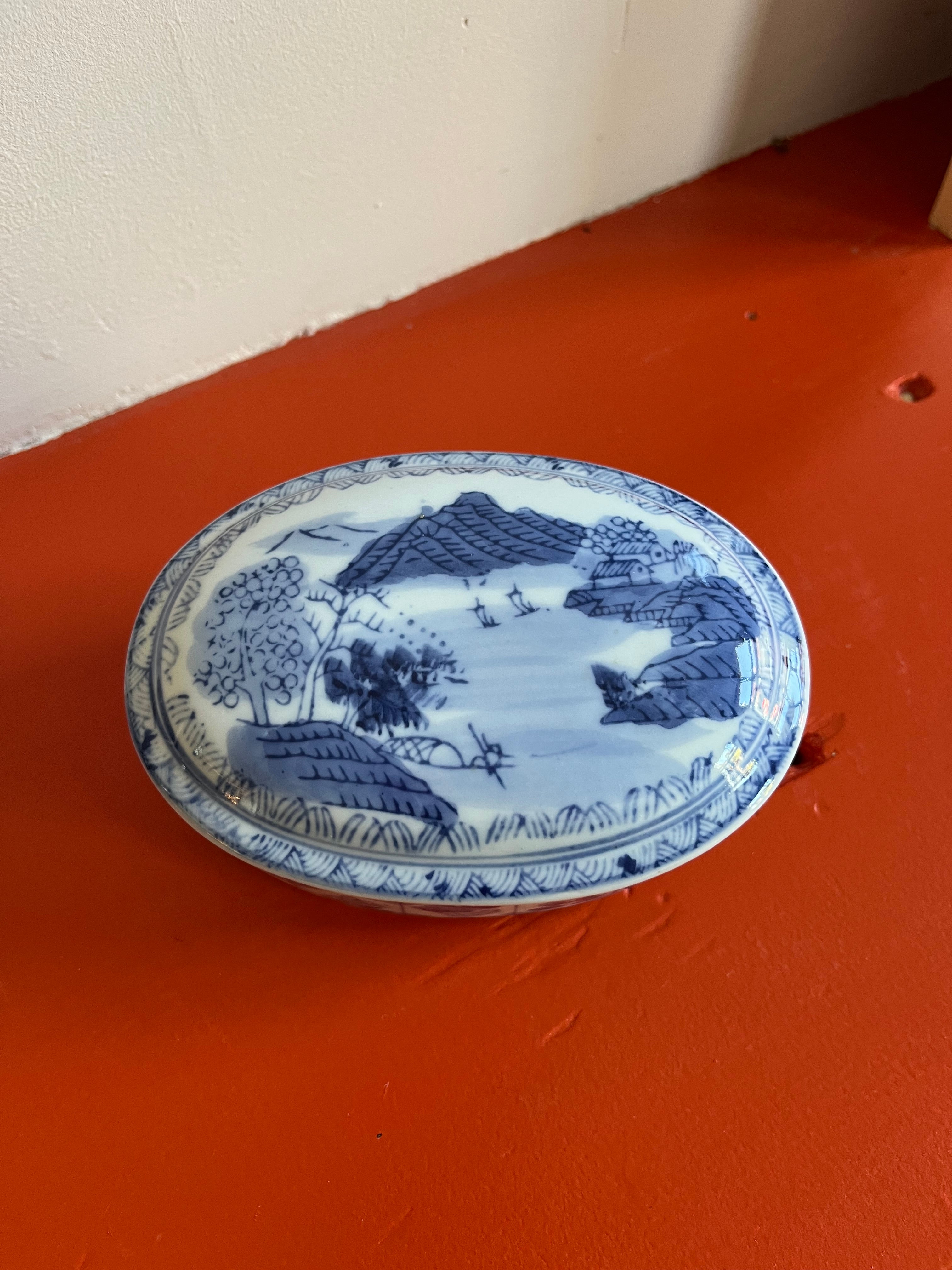 Vintage porseleinen doosje met blauw en wit decor.